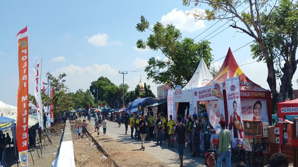 Warga yang memadati bibir pantai untuk menyaksikan ketangkasan para joki katinting menaklukkan ombak. Puluhan Perahu Katinting Adu Cepat, Pantai Tope Jawa Bergemuruh
